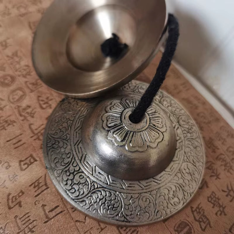 Ornate metal Tibetan meditation bell with intricate engravings for sound healing