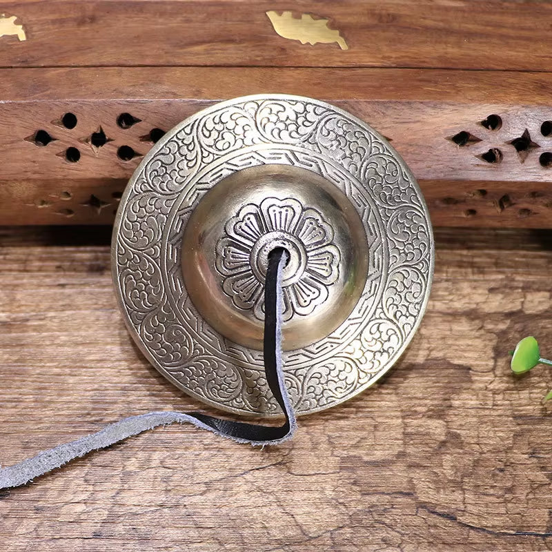 Ornate Tibetan Tingsha Bell with intricate floral engravings for meditation and sound healing