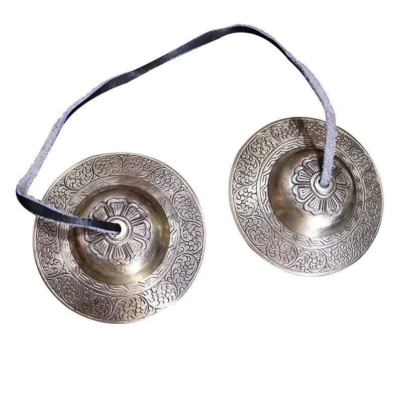 Traditional Tibetan Tingsha cymbals with floral engravings for meditation and sound healing