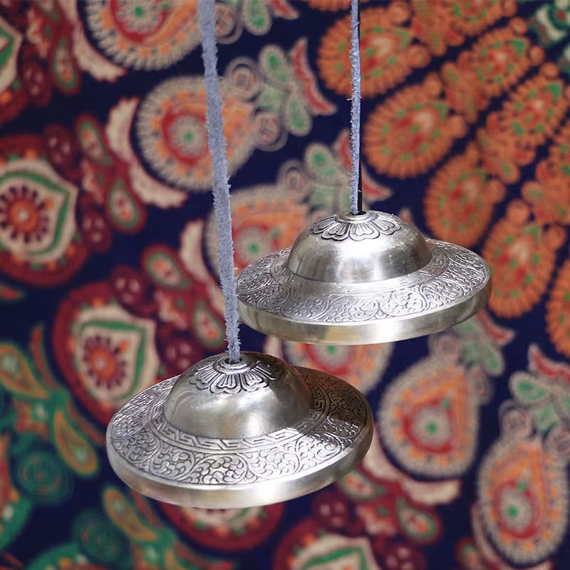 Ornate silver Tibetan Tingsha Bells for meditation and sound healing with decorative patterns
