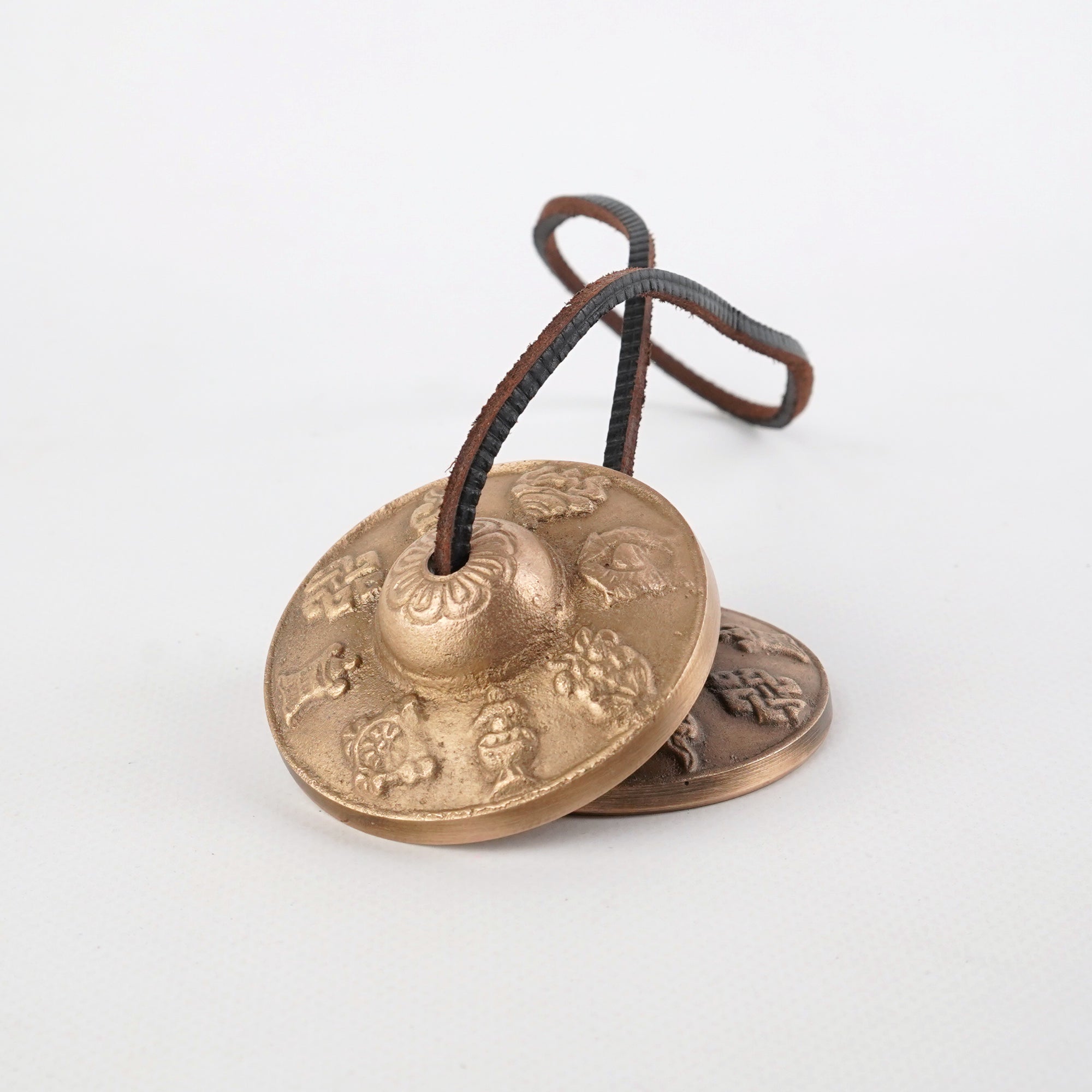 Decorative brass Tibetan Tingsha meditation cymbals with embossed patterns and cord