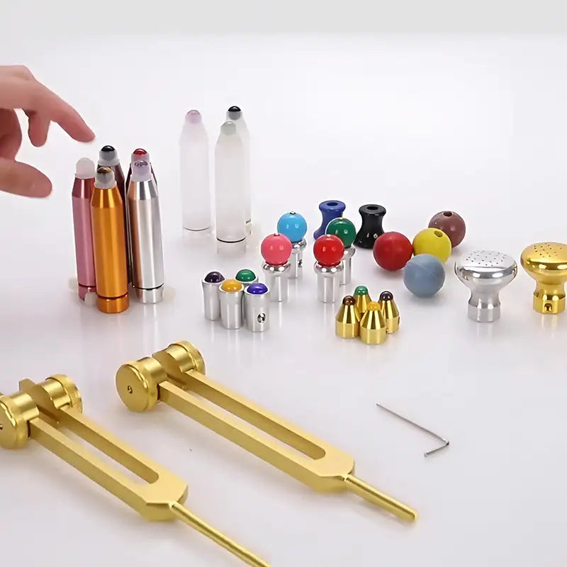 Gold-colored tuning forks with a polished metallic finish and elongated handles.