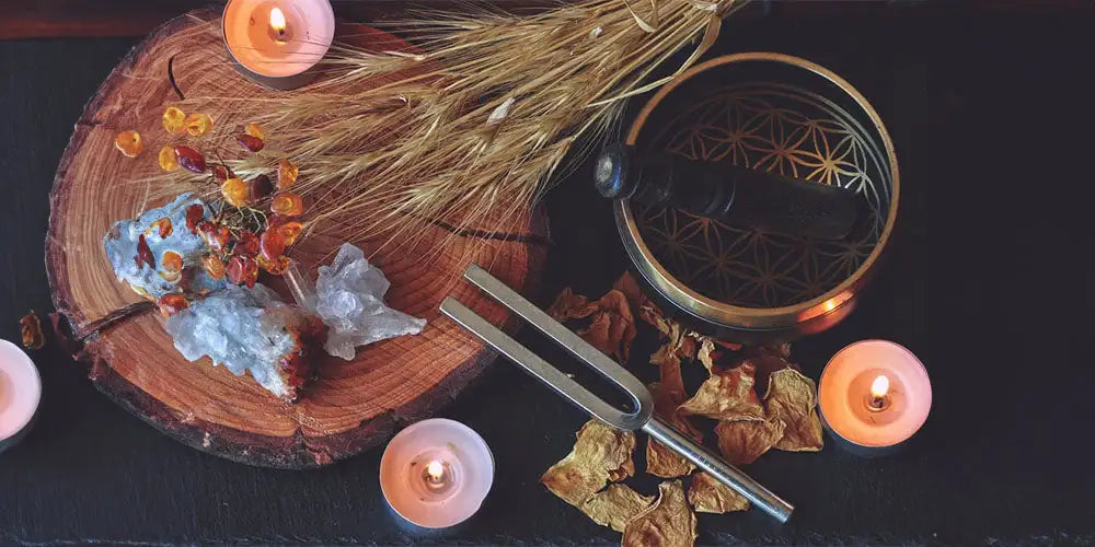 Bronze-colored singing bowl with intricate geometric etchings and a dark wooden handle