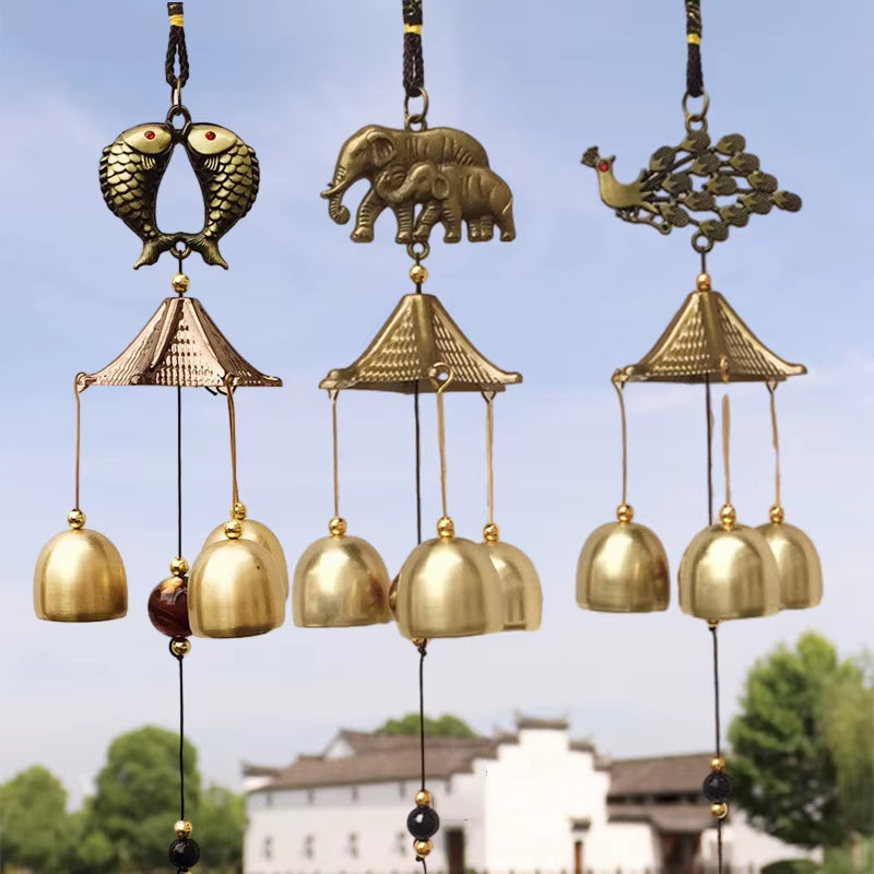 Decorative brass wind chimes with birds, elephants, and peacocks above pagoda bells